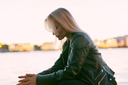 Selective Photography of Woman Sitting Near Body of Water