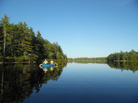 Several Canoes in Shoreline Near Bodies of Water Landscape Photograph