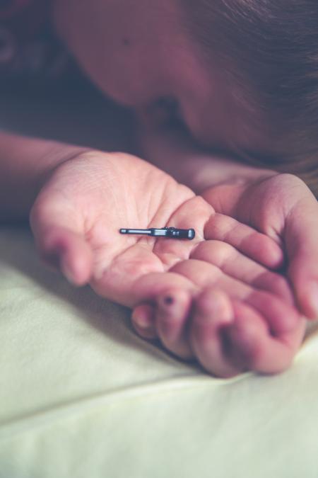 Shallow Focus Photography of Black Plastic Toy on Boy's Palm