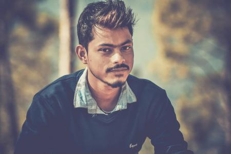 Shallow Focus Photography of Man Wearing Blue Sweater