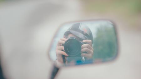 Shallow Focus Photography of Person Holding Dslr Camera in Mirror Reflection