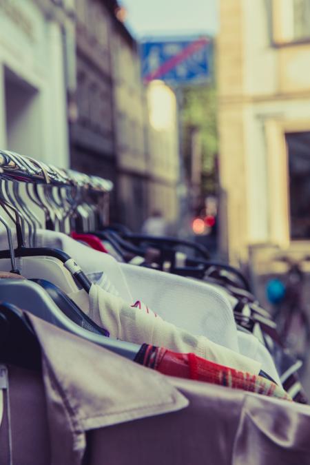 Shallow Focus Photography of Shirts Hang on Silver Clothes Rack Under Sunny Sky