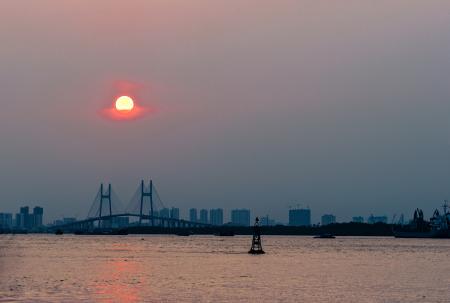 Ship Near Brown Bridge Across Sea during Sunset