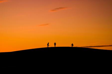 Silhouette of 3 People in Hill during Sunset