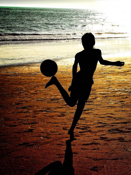Silhouette of a boy playing soccer