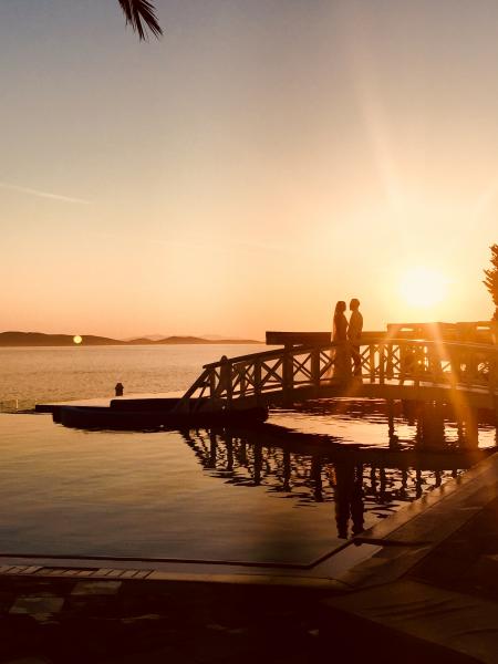 Silhouette of Couple Standing Near Sea Dock at Golden Hour