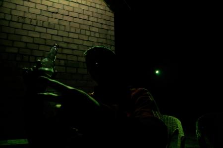 Silhouette of man with bottle of alcohol