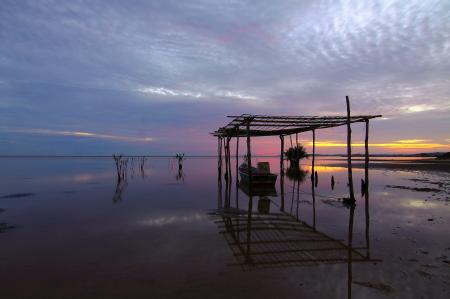 Silhouette of Motorboat on the Body of Water Under Grey and Blue Cloudy Sky during Sunset