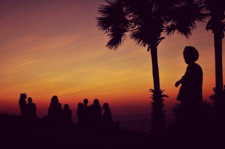 Silhouette of People Standing Under Orange Sky