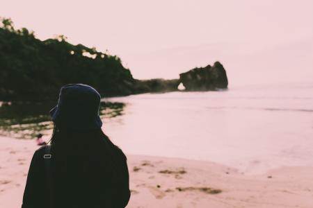 Silhouette of Person Standing on Seashore during Daytime