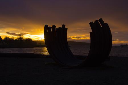 Silhouette Photo of Rock Monolith Nearby Ocean during Golden Hour