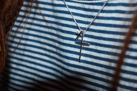 Silver-colored Cross Pendant on Black and White Stripe Textile