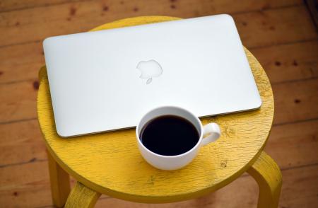 Silver Macbook Beside White Cup