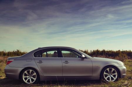 Silver Sedan Parked Far from Green Trees Under Blue Sky during Daytime