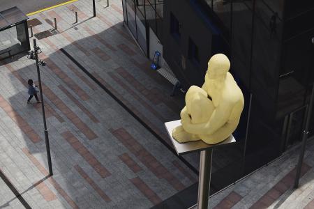 Sitting Man Statue Placed on Gray Metal Post