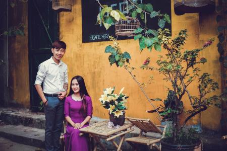 Sitting Woman Wearing Purple Elbow-sleeved Dress and Standing Man Wearing White Dress Shirt