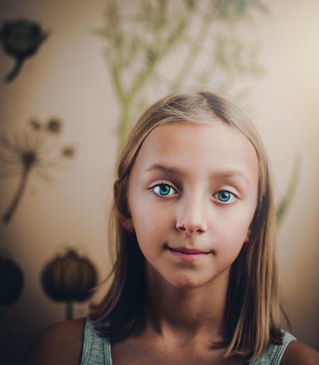 Smiling Girl Standing in White Painted Wall Room