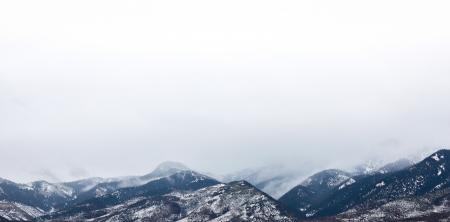 Snow Coated Mountain Under White Clouds