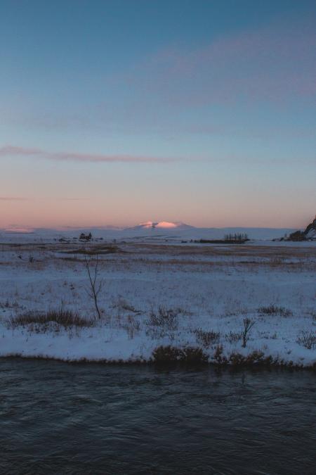 Snow-covered Filed Near Body of Water