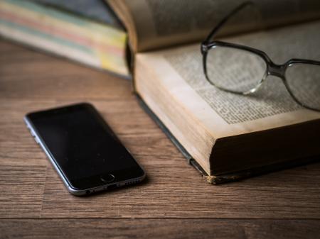 Space Gray Iphone 6 on Top of Brown Table Beside Book