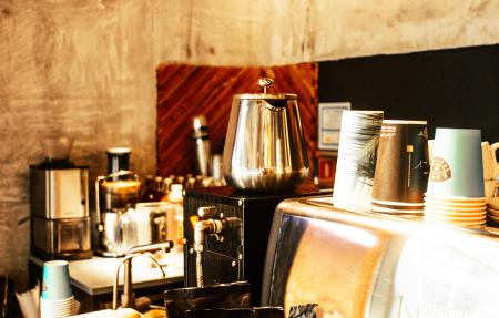 Stainless Steel Coffee Pot and Disposable Cups on Top of Counter