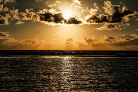 Sun Covered With Clouds Above Sea