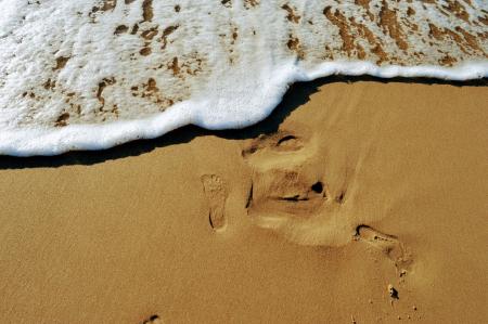 The imprint of a bare foot on the sand