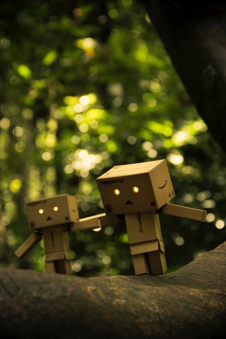 Three Brown Cardboard Box Figures on Brown Surface