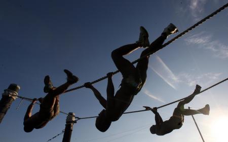 Three Man Climbing on Rope Under the Sunset