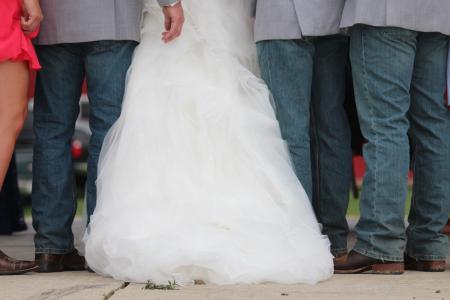 Three Men Wearing Gray Dress Shirt and Blue Denim Pants Between Woman in White Wedding Gown