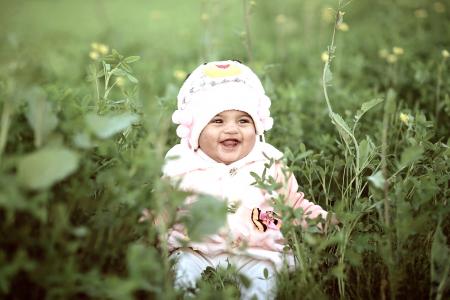 Toddler Wearing Whit Cap on Green Field