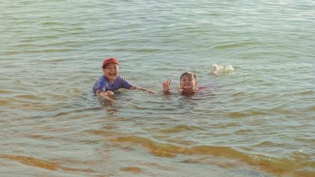 Two Boy on Brown Body of Water