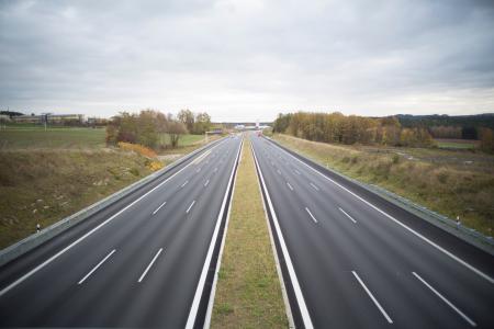 Two Grey Concrete Roads Between Green Grasses