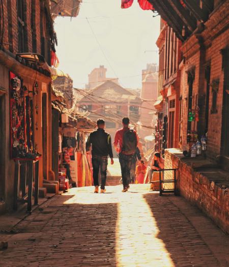 Two Man Walking Beside Brick Houses