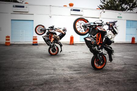 Two Men Riding Orange-and-black Sports Bikes While Doing Exhibition