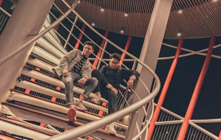 Two Men Sitting on Spiral Stairway