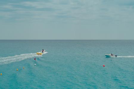 Two People Rides Watercrafts On Body Of Water Under Clear Blue Sky