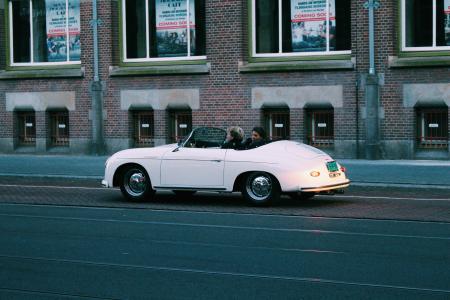 Two People Riding White Classic Convertible Car