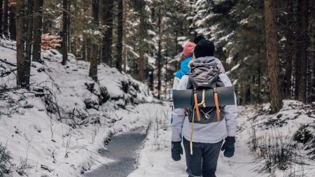 Two People Walking in Woods With Snow