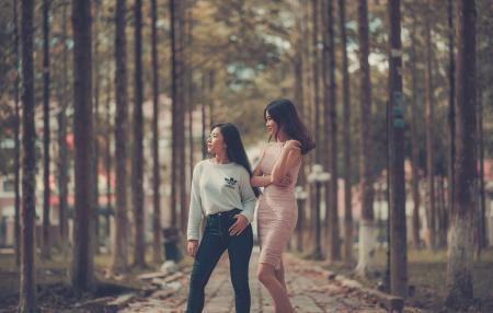 Two Woman Standing on Sidewalk Near Trees