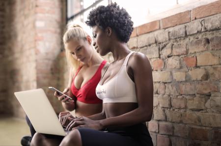 Two Woman Wearing Red and White Sports Bras