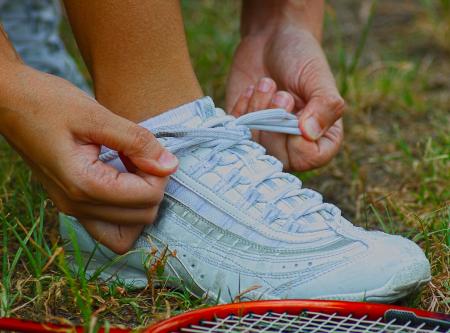 Tying Shoes Ready For A Game Of Badminton