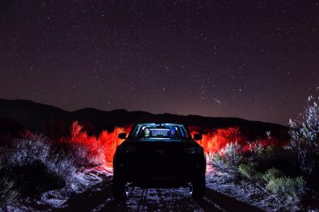 Vehicle on Road Along Green Grass during Night