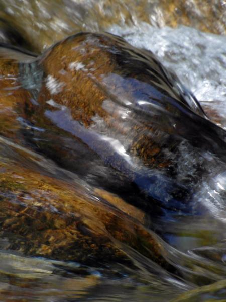 Water over smooth boulders in river