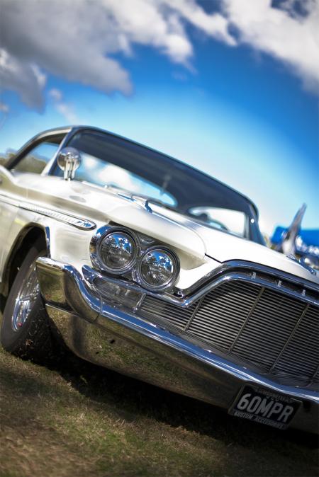 White and Black Car Parked on Green Grass Field Under Blue Cloudy Sky