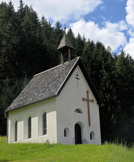 White and Black Cathedral Surrounded by Trees Under White Clouds