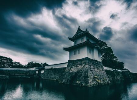 White and Black Concrete Building Near Body of Water Under Gray Cloudy Sky