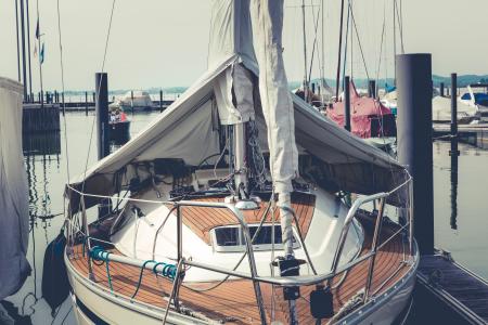 White and Brown Boat on Dock Near Speed Boat