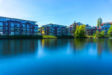 White and Brown Concrete Building Beside Body of Water Under Blue Sky during Datytime