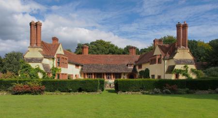 White and Brown Painted House Near Green Leafed Trees Under Sunny Blue Cloudy Sky